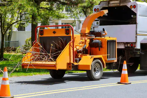 Wood chipper and crew truck set up safely on a residential street